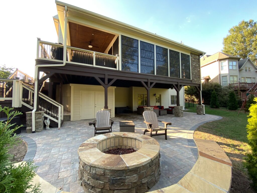 Custom back patio with built-in stone firepit and Adirondack chairs.